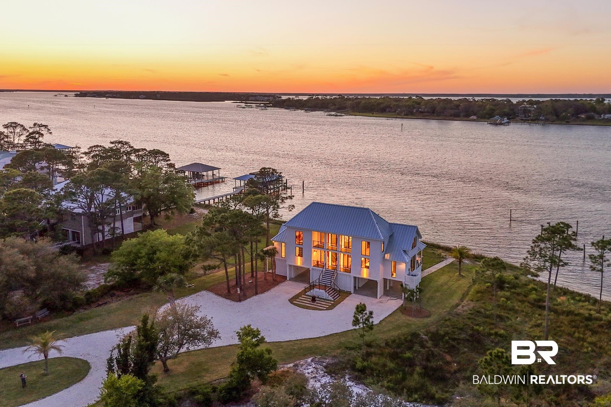 33349 River Road Orange Beach, AL 36561 - Photo 7 of 61 Waterfront residence featuring a metal roof, multiple levels of windows, and an elevated foundation
