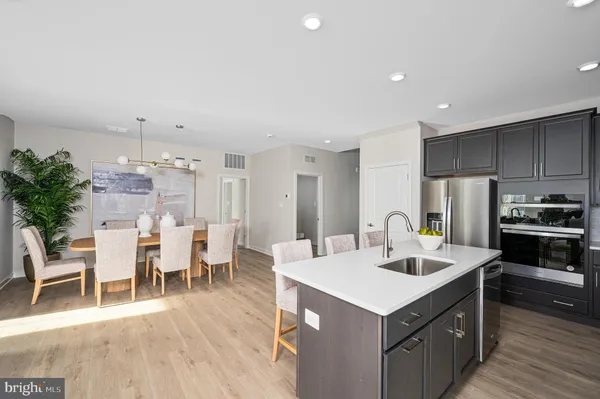 a kitchen with a dining table chairs sink and stove