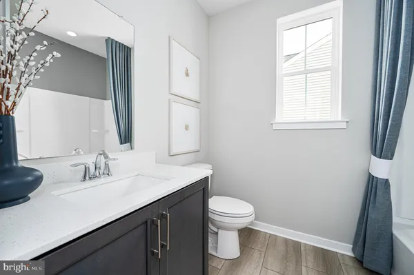 a bathroom with a sink a toilet and a mirror
