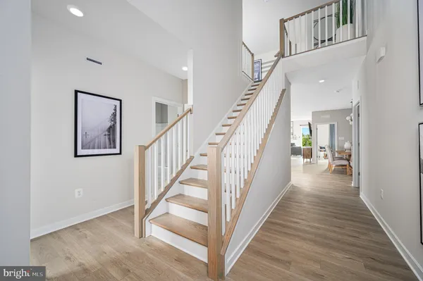 a view of staircase with lots of frames on wall and wooden floor