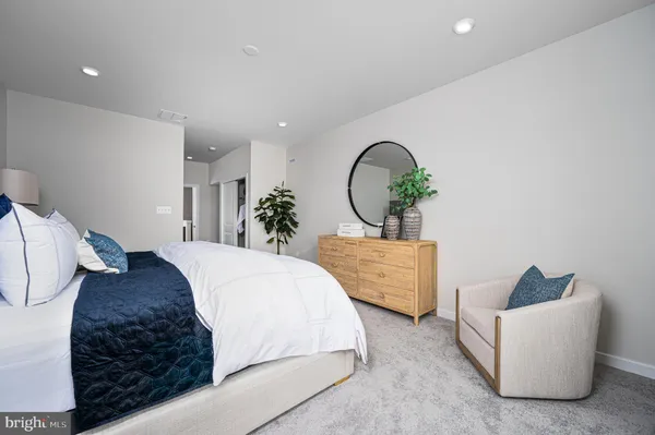 a bed room with a bed mirror and a couch
