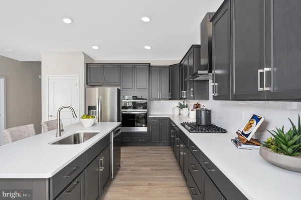 a large kitchen with lots of counter space and wooden floor