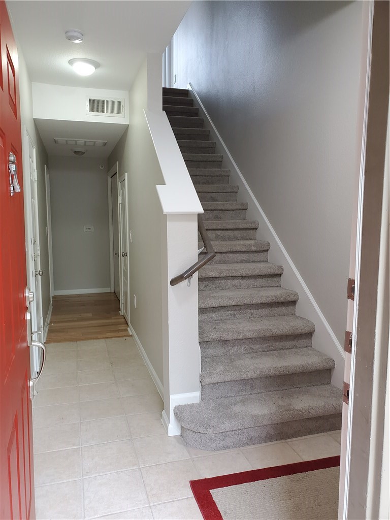 11203 Ranch Road 2222, Unit 302 Austin, TX 78732 - Photo 5 of 18 From front door stairs go up to living area and hall leads to laundry area and 2nd bedroom