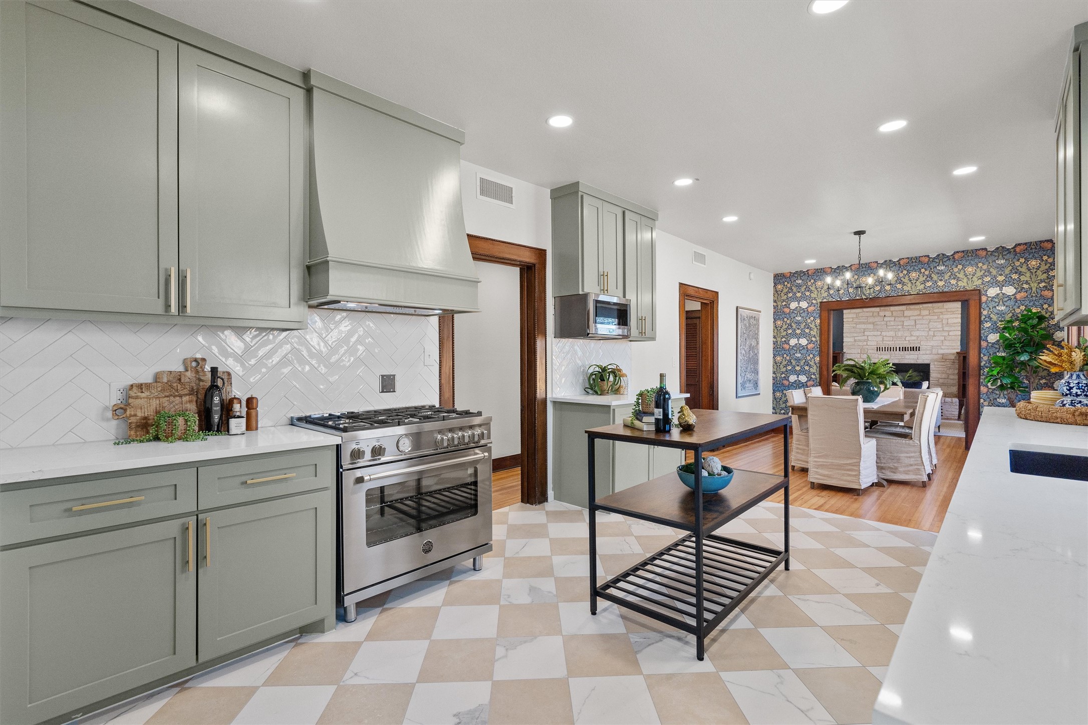 1605 South Austin Avenue Georgetown, TX 78626 - Photo 12 of 40 Kitchen featuring wallpapered walls, light stone countertops, high end stainless steel range, suspended lighting, and gray cabinets