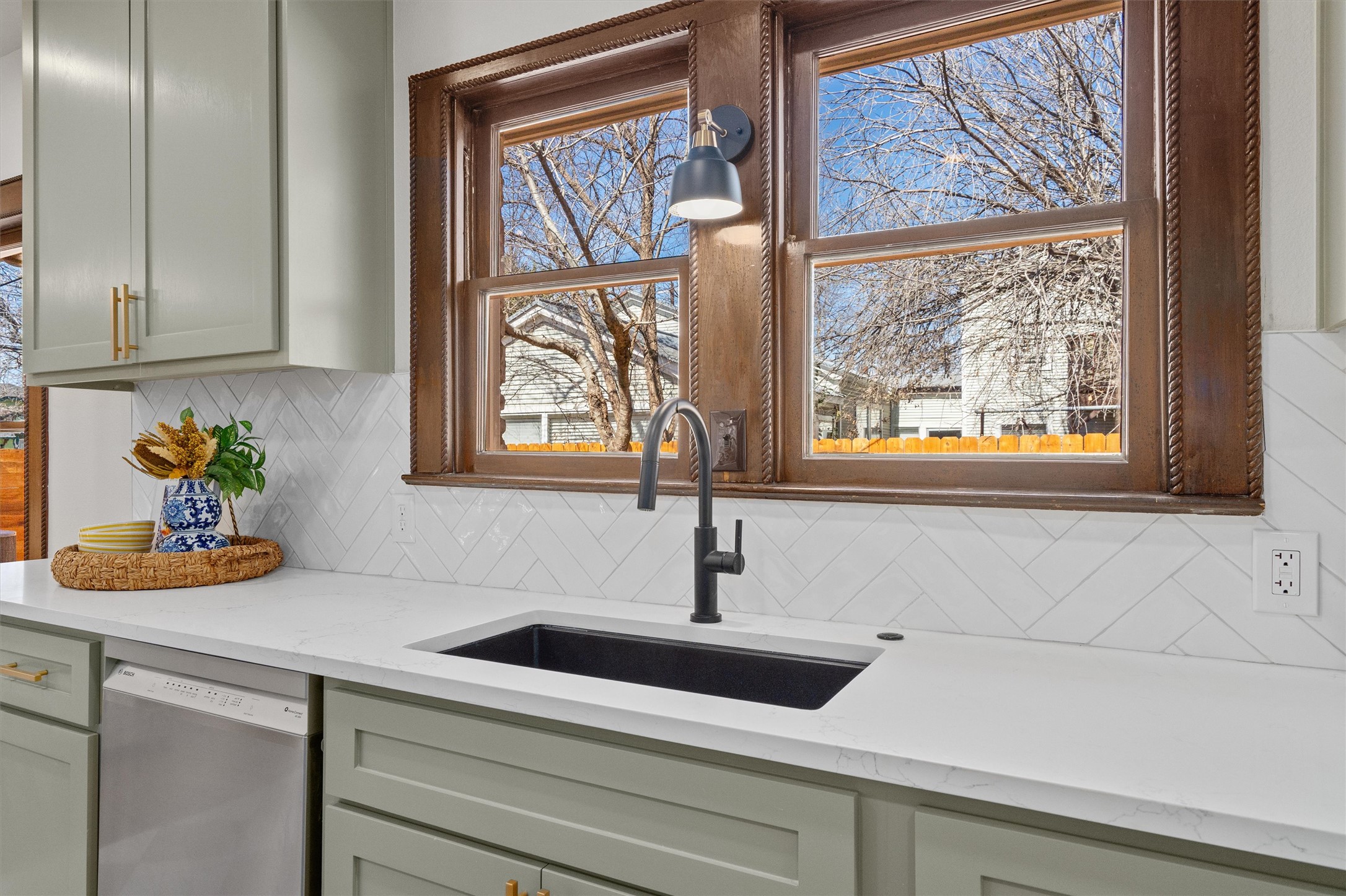 1605 South Austin Avenue Georgetown, TX 78626 - Photo 13 of 40 Kitchen featuring light stone counters, dishwasher, and decorative backsplash