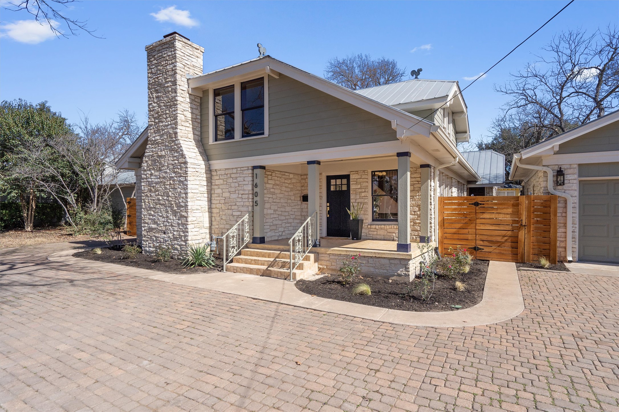 1605 South Austin Avenue Georgetown, TX 78626 - Photo 3 of 40 View of front facade featuring a porch, stone siding, a garage, a gate, and a chimney
