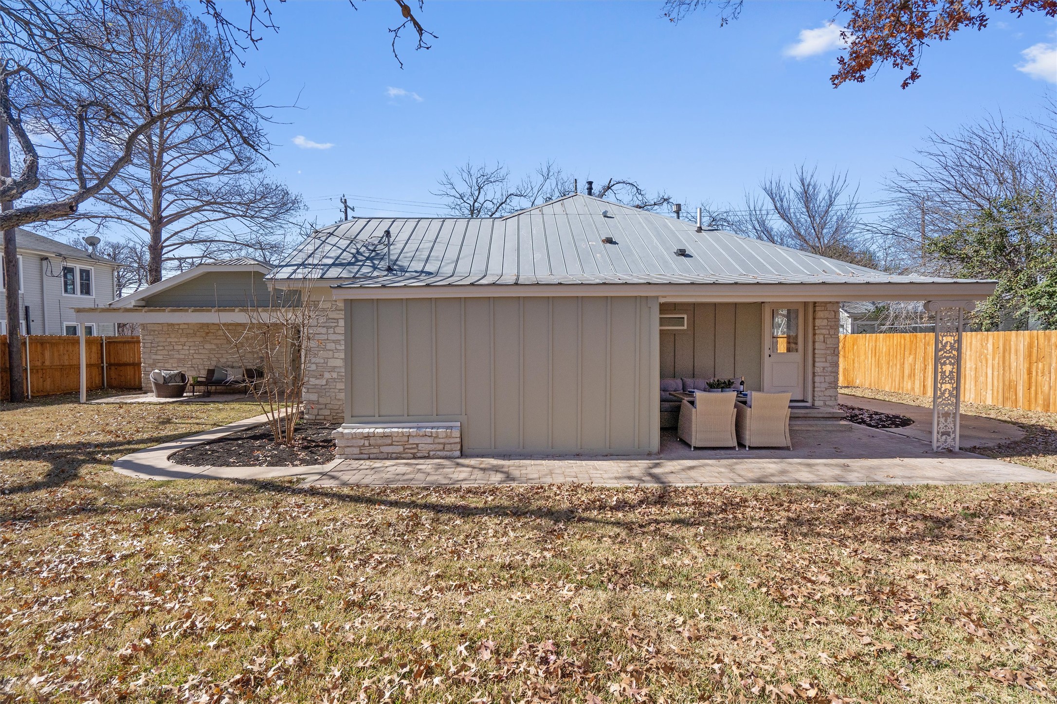 1605 South Austin Avenue Georgetown, TX 78626 - Photo 31 of 40 Rear view of house with a fenced backyard, board and batten siding, and a patio area