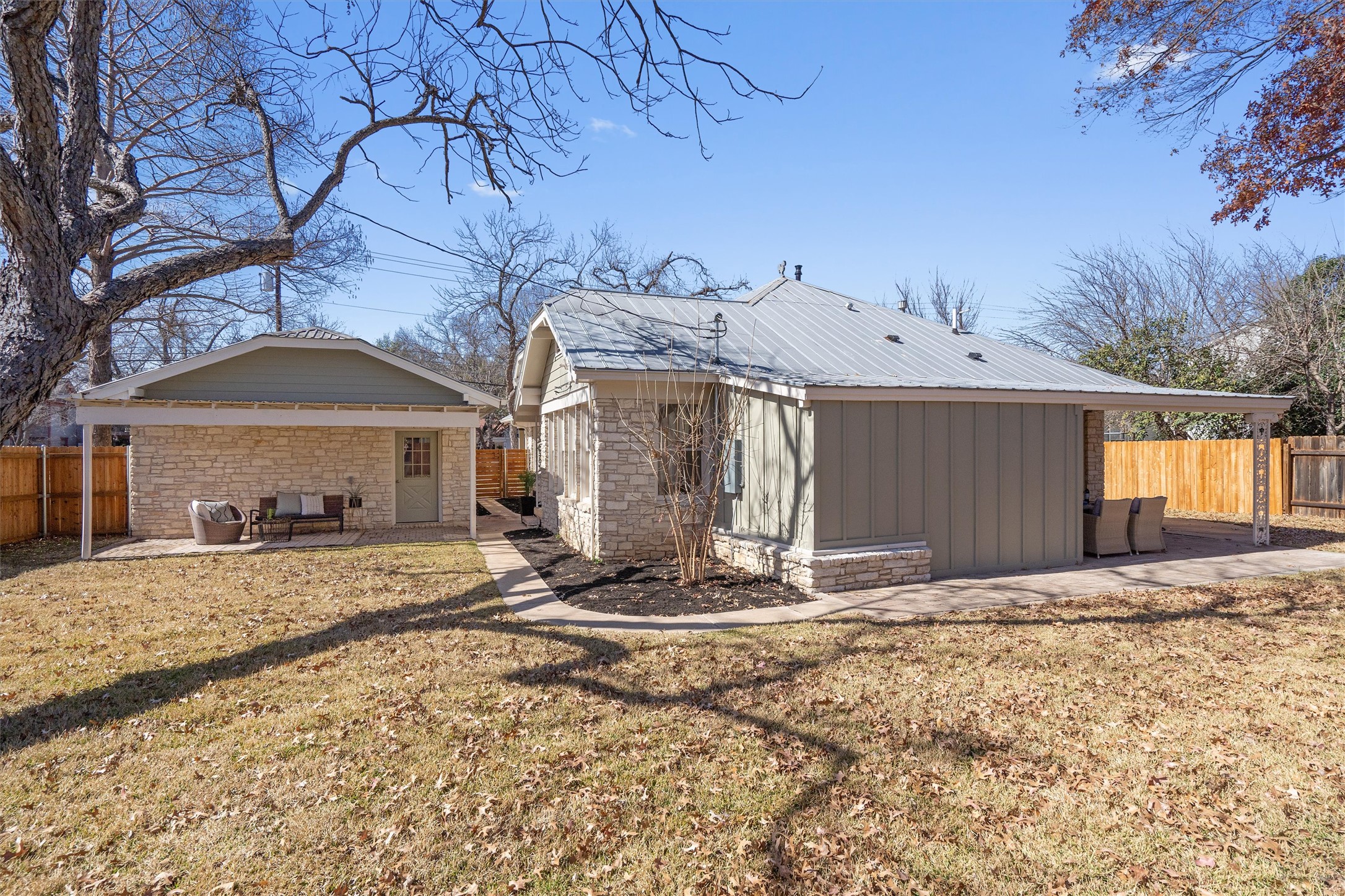 1605 South Austin Avenue Georgetown, TX 78626 - Photo 32 of 40 Back of house with a fenced backyard, a patio, an outdoor structure, and a metal roof