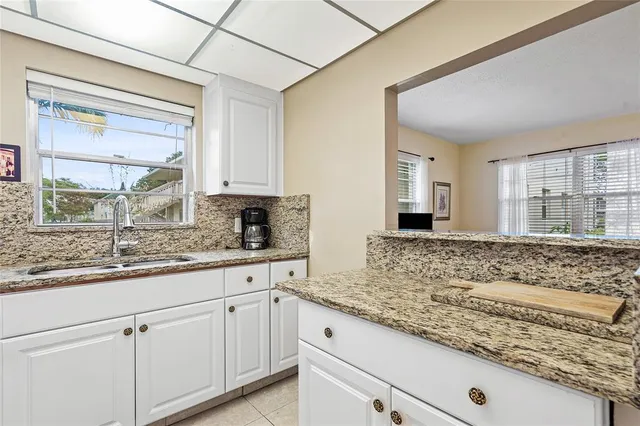 a kitchen with granite countertop stainless steel appliances sink stove and cabinets
