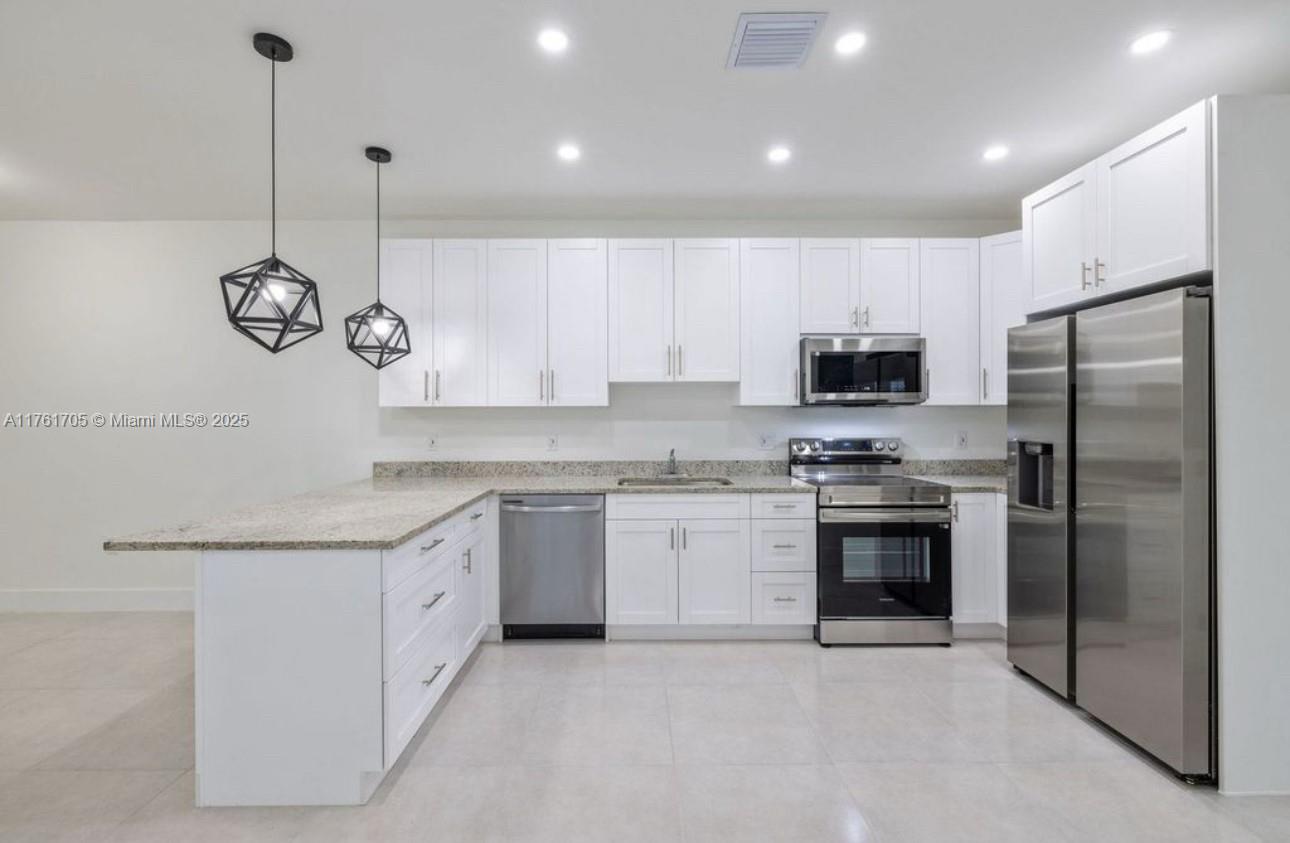 11240 Southwest 187th Street, Unit 11240 Miami, FL 33157 - Photo 3 of 9 a kitchen with a sink stainless steel appliances and cabinets