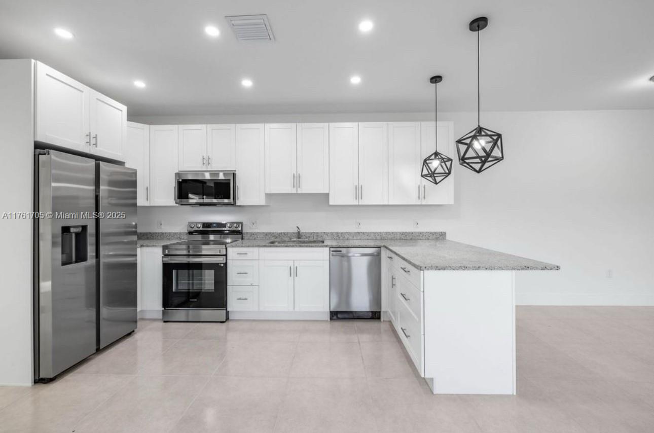 11240 Southwest 187th Street, Unit 11240 Miami, FL 33157 - Photo 4 of 9 a kitchen with a sink stainless steel appliances and cabinets