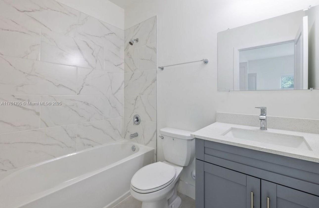 11240 Southwest 187th Street, Unit 11240 Miami, FL 33157 - Photo 5 of 9 a bathroom with a sink a toilet and a mirror