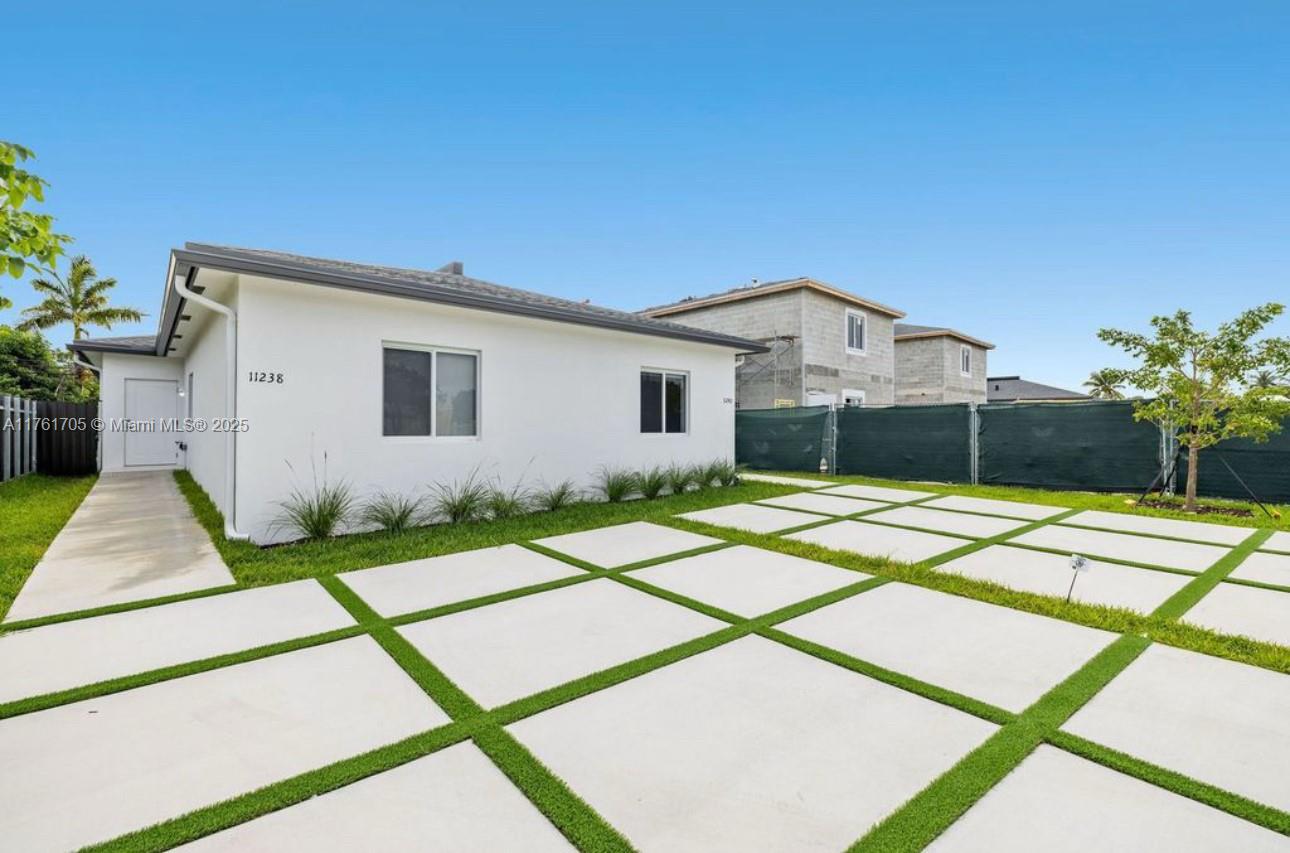 11240 Southwest 187th Street, Unit 11240 Miami, FL 33157 - Photo 7 of 9 a front view of a house with a yard and garage