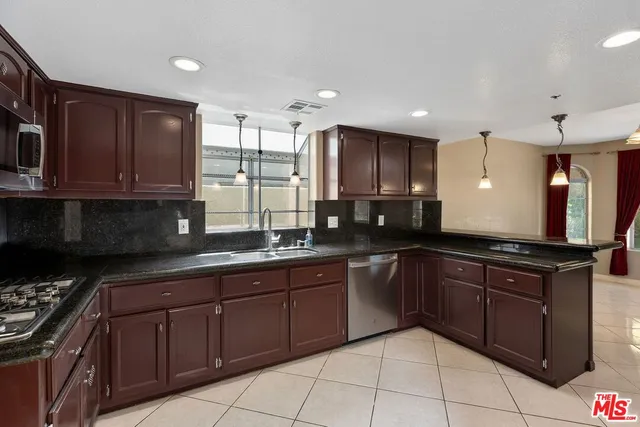 a kitchen with stainless steel appliances granite countertop a stove a sink and a microwave