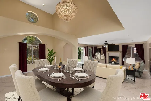 a living room with furniture a fireplace and a large window