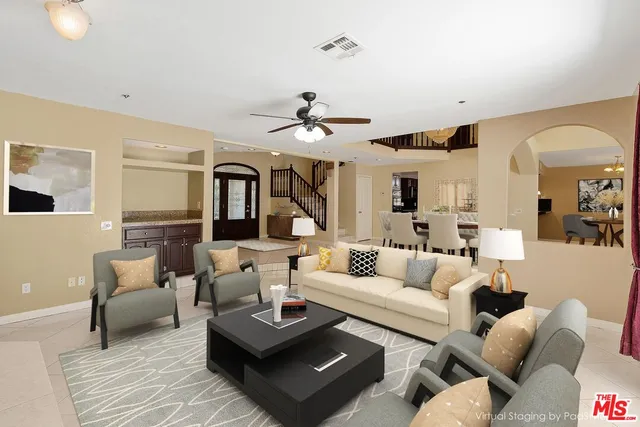 a living room with furniture ceiling fan and a rug