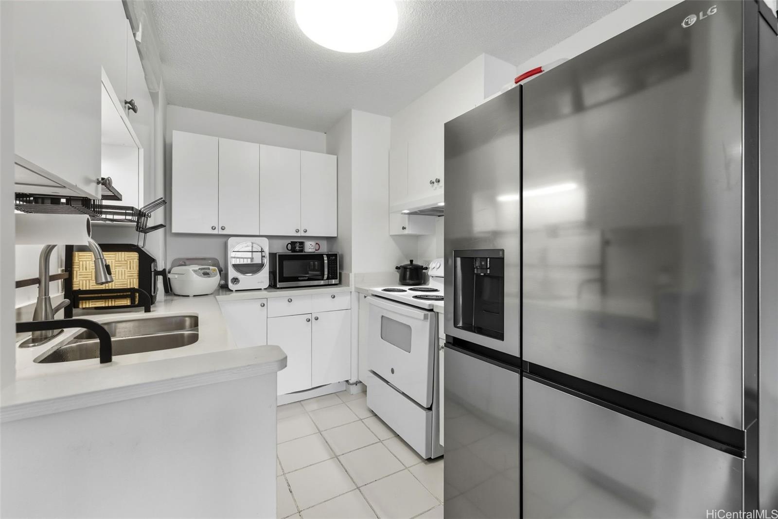 3161 Ala Ilima Street, Unit 1616 Honolulu, HI 96818 - Photo 6 of 23 a kitchen with cabinets and appliances