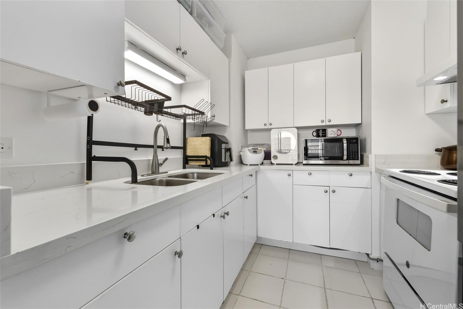 3161 Ala Ilima Street, Unit 1616 Honolulu, HI 96818 - Photo 7 of 23 a kitchen with cabinets and appliances