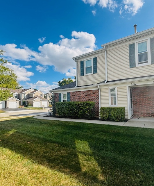 266 Greensboro Court, Unit A Elk Grove Village, IL 60007 - Photo 10 of 10 a front view of a house with a garden