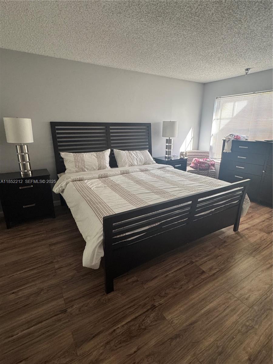 1165 Crystal Way, Unit B Delray Beach, FL 33444 - Photo 14 of 16 a bedroom with bed and wooden floor