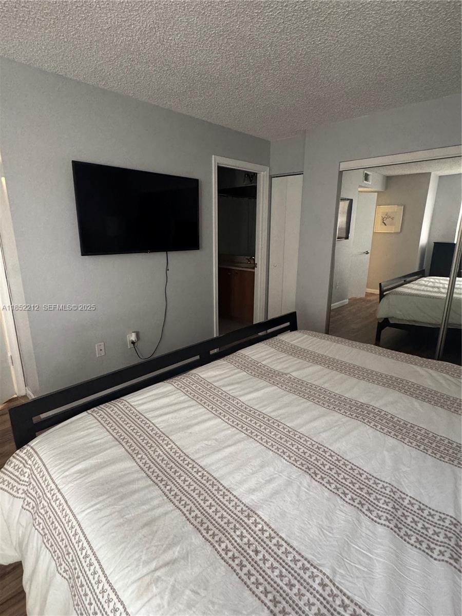 1165 Crystal Way, Unit B Delray Beach, FL 33444 - Photo 15 of 16 a bedroom with a bed and a mirror