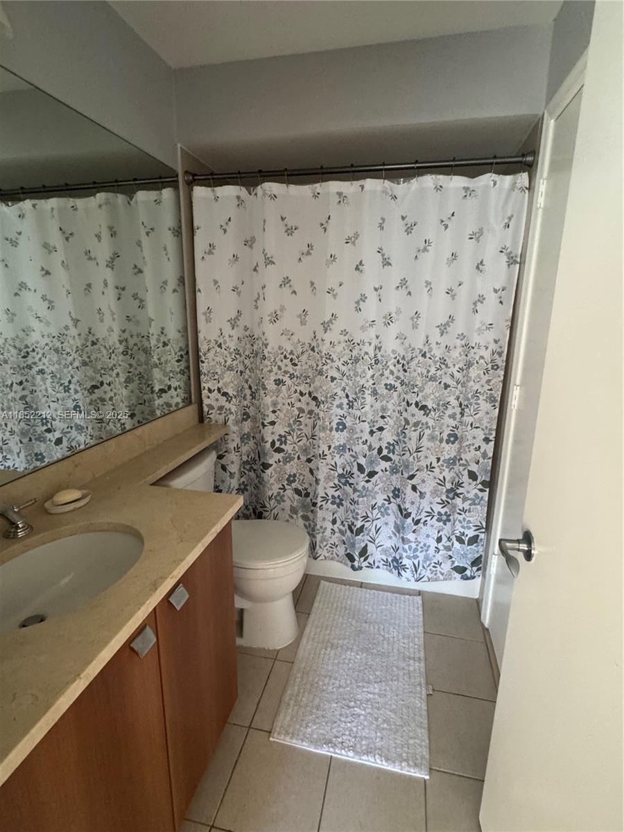 1165 Crystal Way, Unit B Delray Beach, FL 33444 - Photo 16 of 16 a bathroom with a toilet and a shower curtain