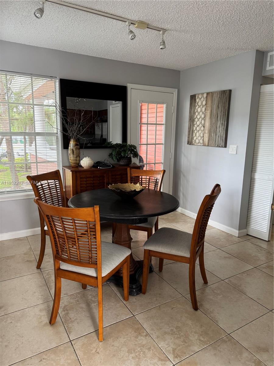 1165 Crystal Way, Unit B Delray Beach, FL 33444 - Photo 5 of 16 a dining room with furniture and window