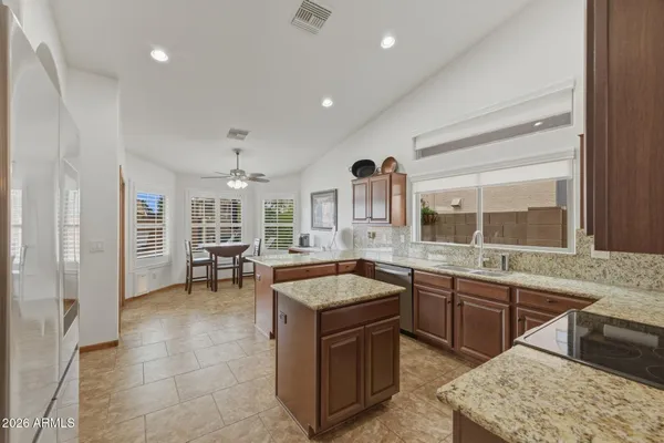 a kitchen with stainless steel appliances granite countertop a sink refrigerator and cabinets