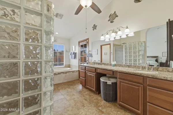 a bathroom with a granite countertop sink a large mirror and a bathtub with shower