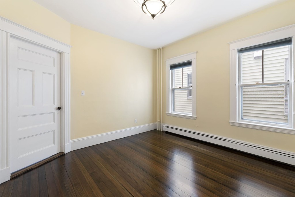 48 Rice Street, Unit 1 Cambridge, MA 02140 - Photo 11 of 16 a view of an empty room with wooden floor and a window
