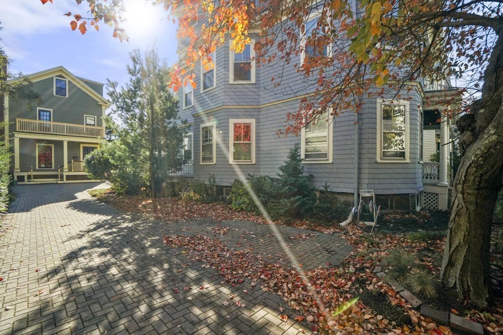 48 Rice Street, Unit 1 Cambridge, MA 02140 - Photo 16 of 16 a view of a brick house next to a yard with large trees