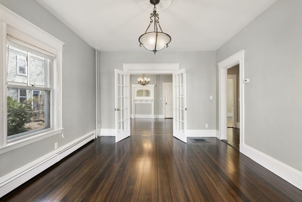 48 Rice Street, Unit 1 Cambridge, MA 02140 - Photo 9 of 16 a view of an empty room with wooden floor and a window