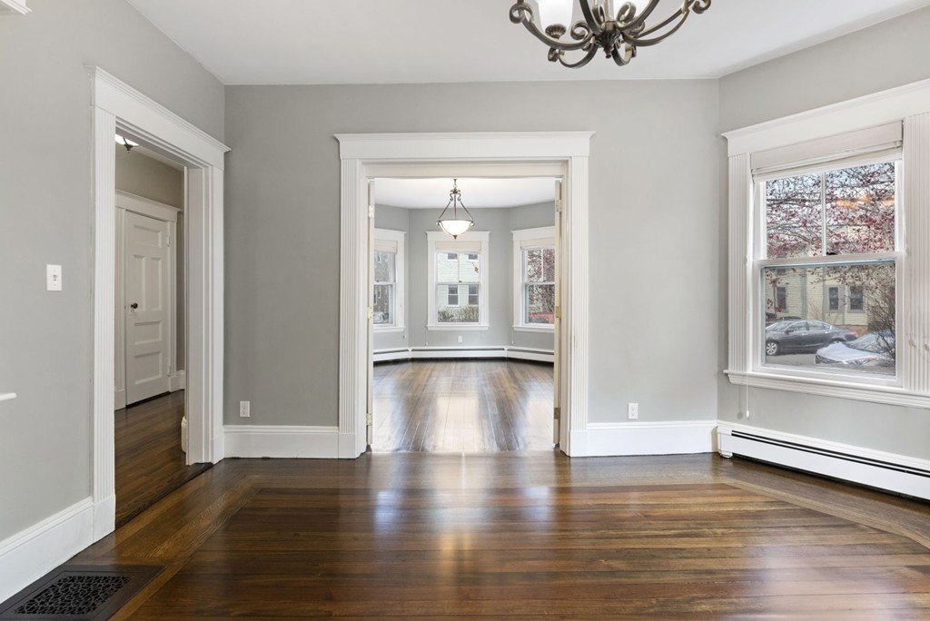 48 Rice Street, Unit 1 Cambridge, MA 02140 - Photo 10 of 16 a view of a big room with wooden floor and windows