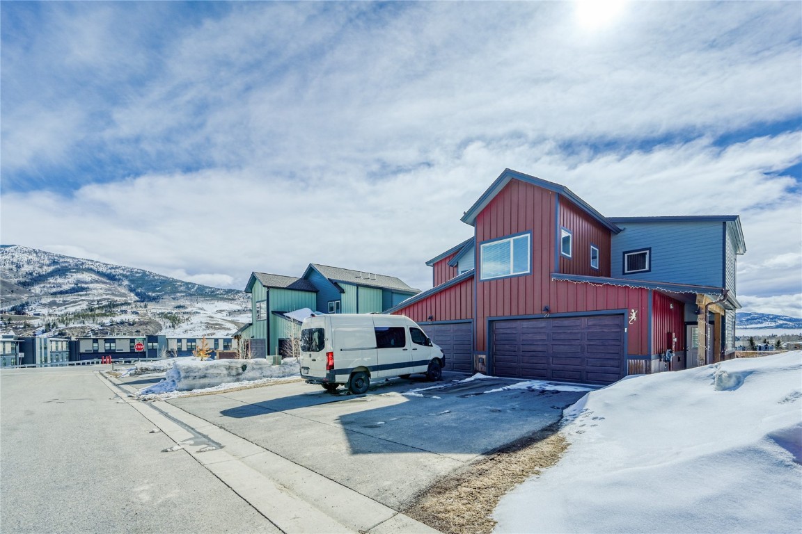 29 Haymaker Street, Unit 2B Silverthorne, CO 80498 - Photo 5 of 28 View of snowy exterior with board and batten siding, concrete driveway, a mountain view, and an attached garage