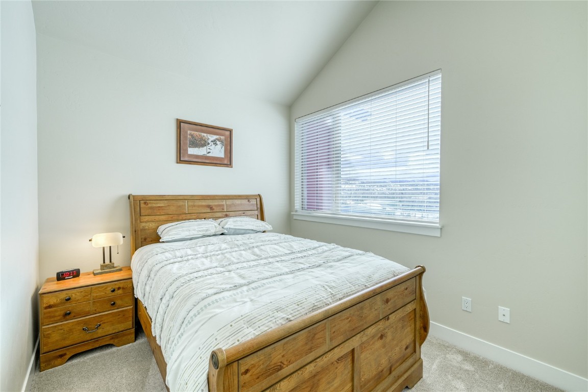 29 Haymaker Street, Unit 2B Silverthorne, CO 80498 - Photo 6 of 28 Bedroom with baseboards, vaulted ceiling, and light carpet