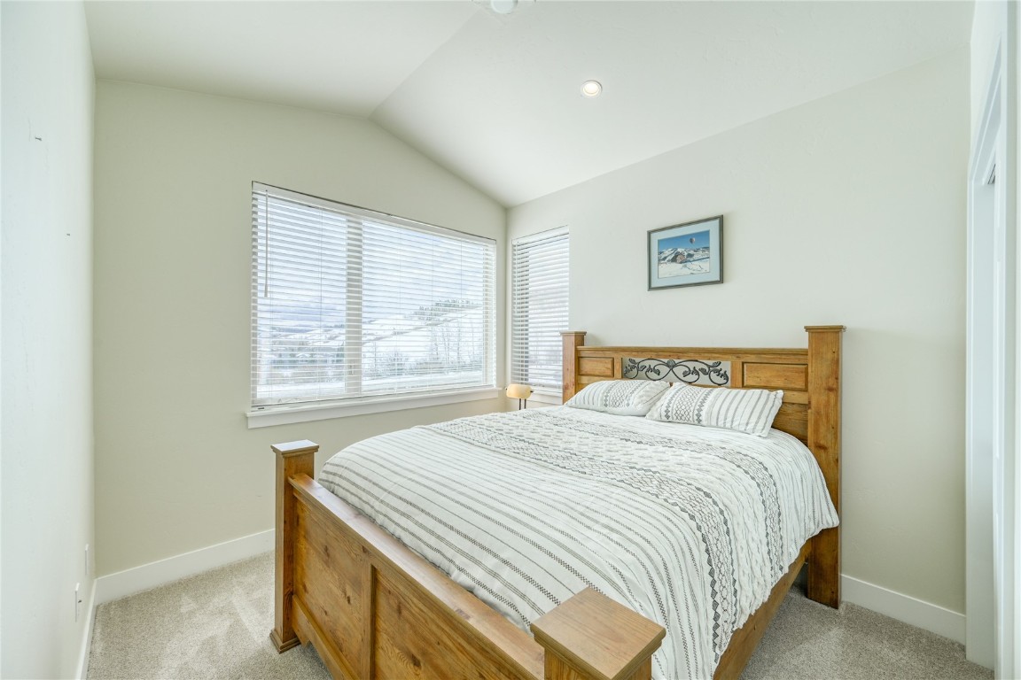 29 Haymaker Street, Unit 2B Silverthorne, CO 80498 - Photo 8 of 28 Bedroom with light carpet, baseboards, and lofted ceiling