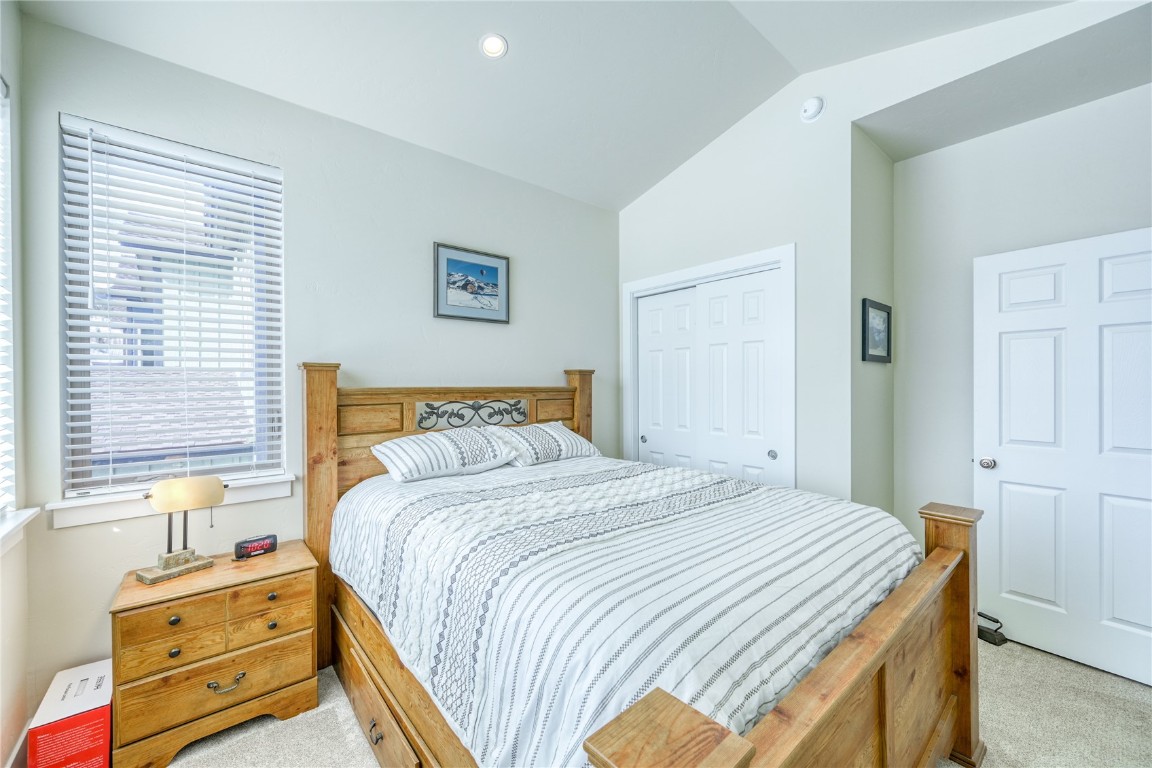 29 Haymaker Street, Unit 2B Silverthorne, CO 80498 - Photo 9 of 28 Bedroom with a closet, vaulted ceiling, and light carpet