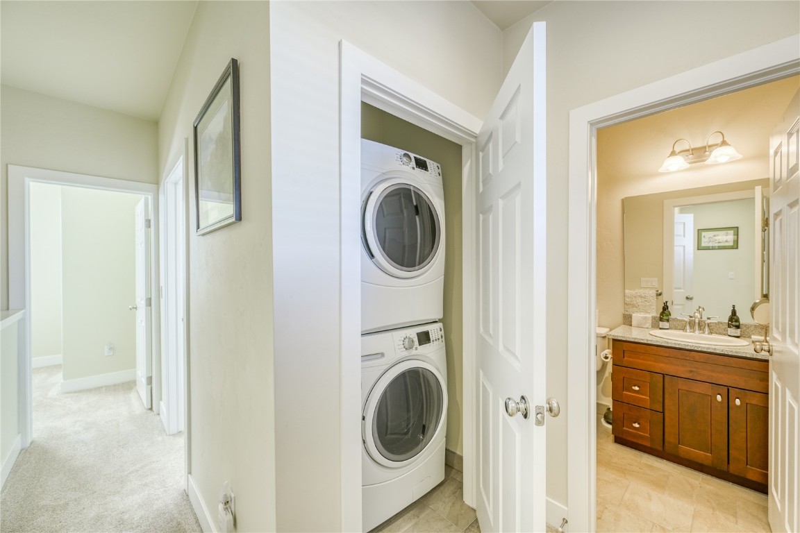 29 Haymaker Street, Unit 2B Silverthorne, CO 80498 - Photo 10 of 28 Laundry room with stacked washer and dryer, a sink, laundry area, baseboards, and light colored carpet