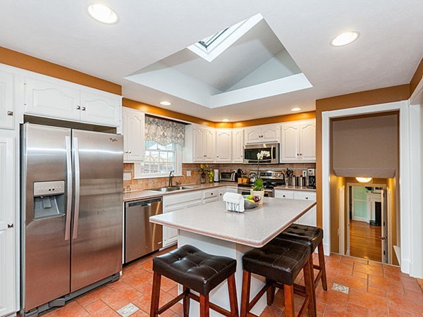 a kitchen with a sink a refrigerator and chairs