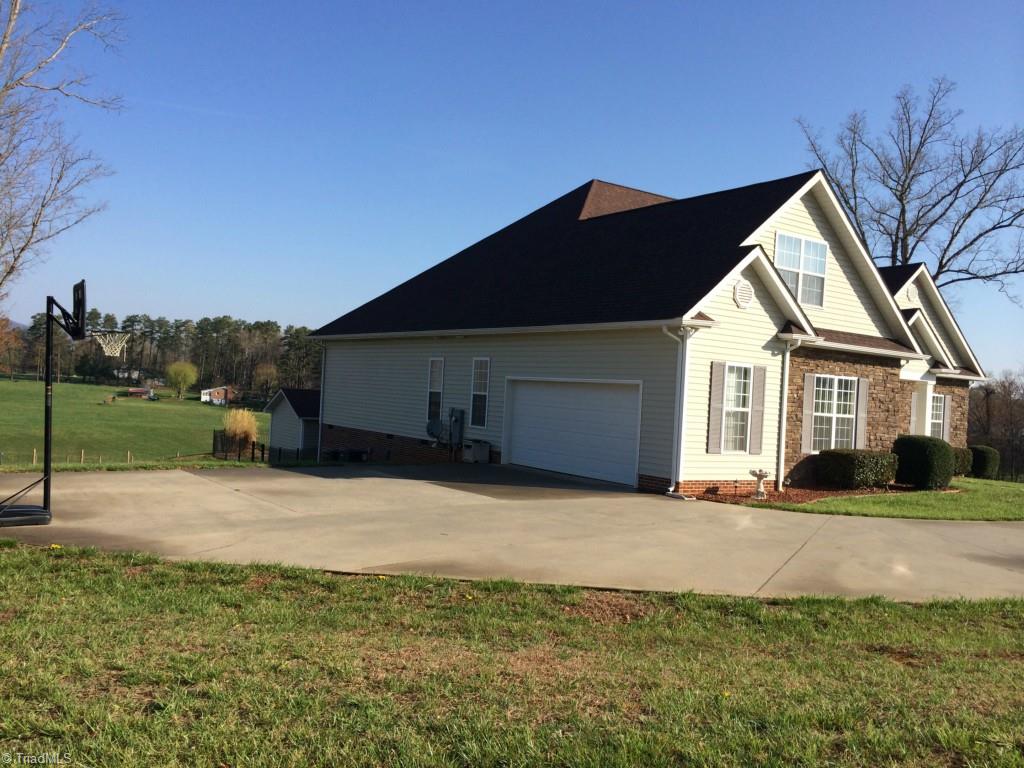 175 Sourwood Road State Road, NC 28676 - Photo 16 of 24 Left side of the home offering parking and a double garage and space for a good game of basketball.