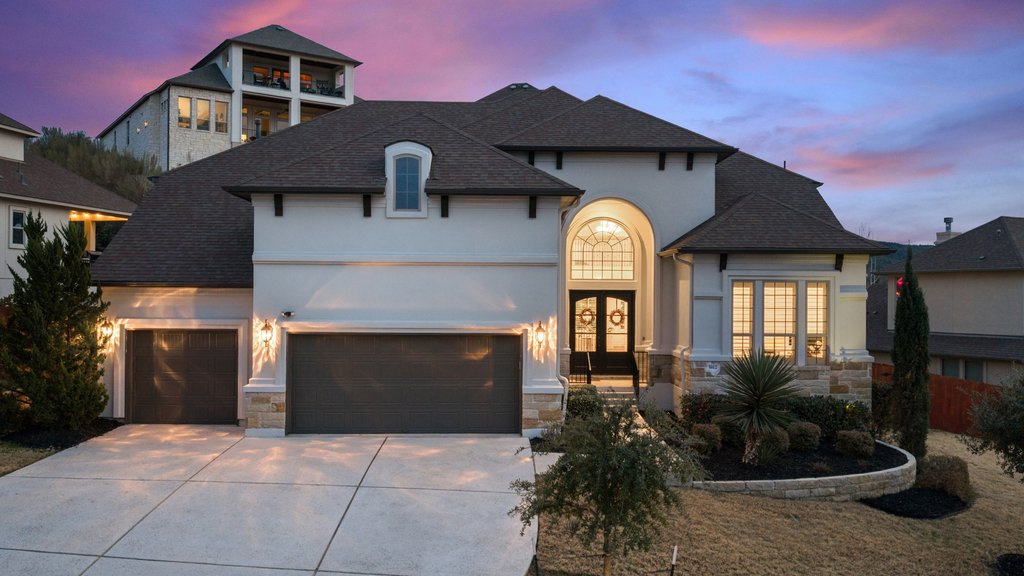 5812 Davenport Divide Road Austin, TX 78738 - Photo 1 of 40 A welcoming facade that truly shines at sunset, where soft lighting and the arched entry create an inviting arrival each evening.