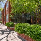 a view of a backyard with potted plants and large trees