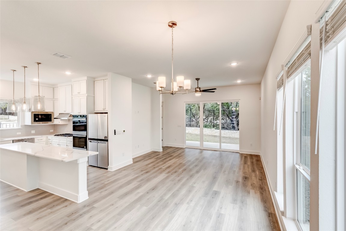 2000 Kit Circle Austin, TX 78758 - Photo 34 of 34 Kitchen featuring white cabinetry, hanging light fixtures, a chandelier, appliances with stainless steel finishes, and open floor plan
