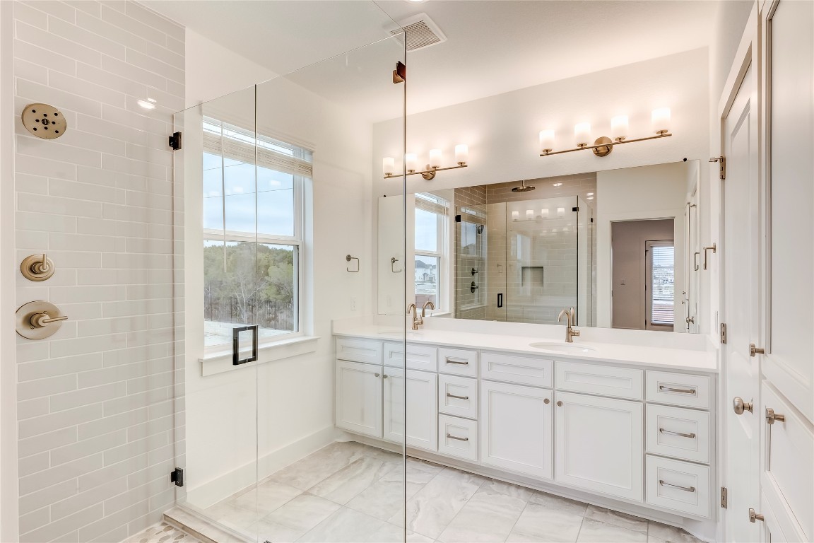 2000 Kit Circle Austin, TX 78758 - Photo 22 of 34 Full bath featuring vanity, a shower stall, and light marble finish floors
