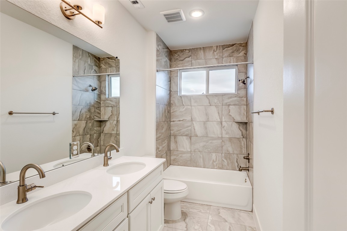 2000 Kit Circle Austin, TX 78758 - Photo 26 of 34 Bathroom with double vanity, bathing tub / shower combination, and light marble finish floors