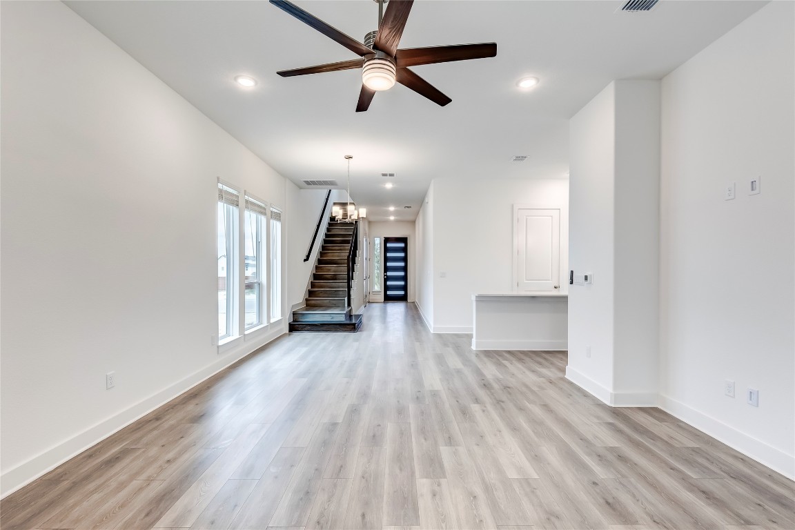 2000 Kit Circle Austin, TX 78758 - Photo 7 of 34 Unfurnished living room featuring stairway, light wood-type flooring, ceiling fan, recessed lighting, and a chandelier