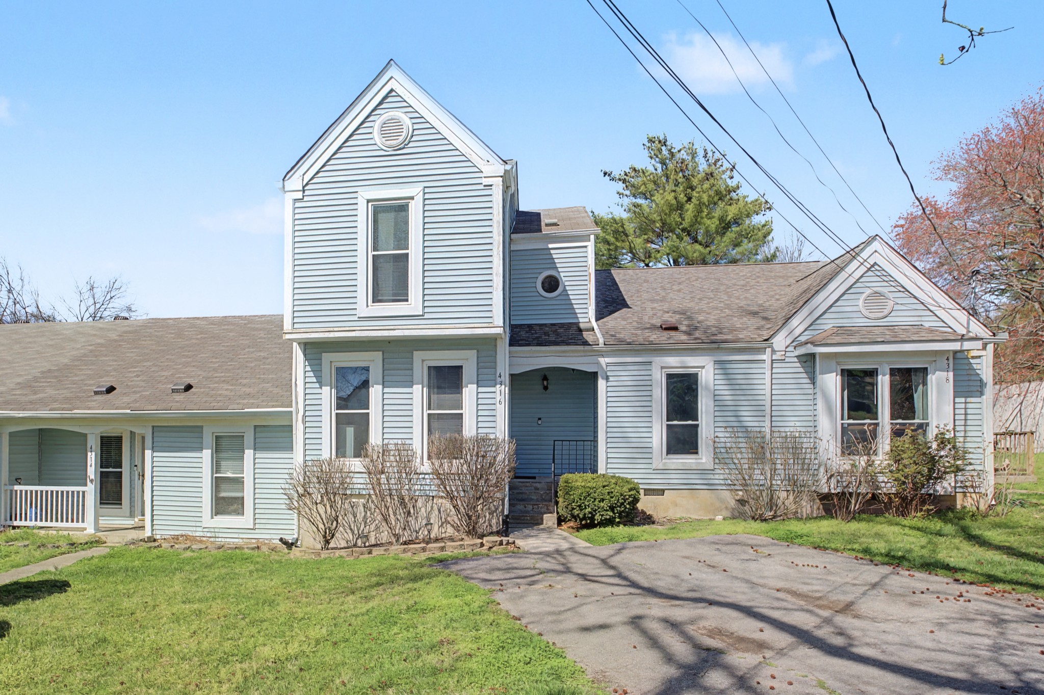 a front view of a house with a yard and trees