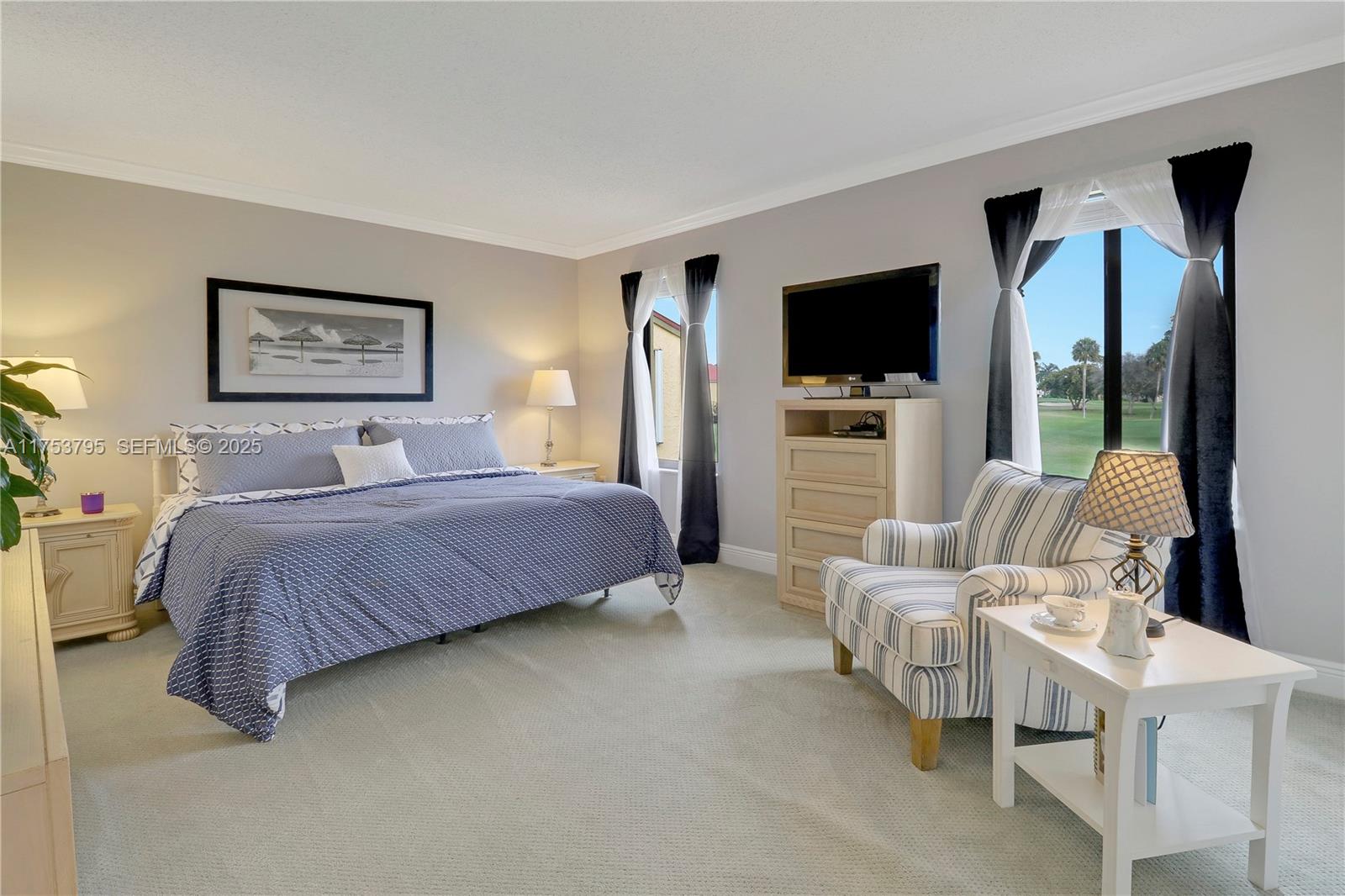 5313 Southeast Miles Grant Road, Unit 206 Stuart, FL 34997 - Photo 16 of 39 a bedroom with a bed and a flat screen tv