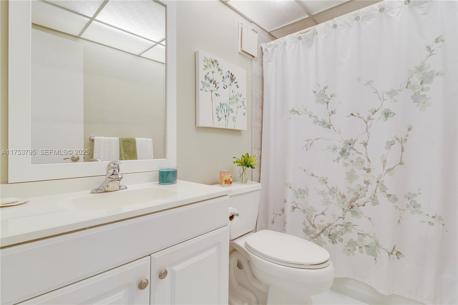 5313 Southeast Miles Grant Road, Unit 206 Stuart, FL 34997 - Photo 22 of 39 a bathroom with a sink a toilet and a mirror
