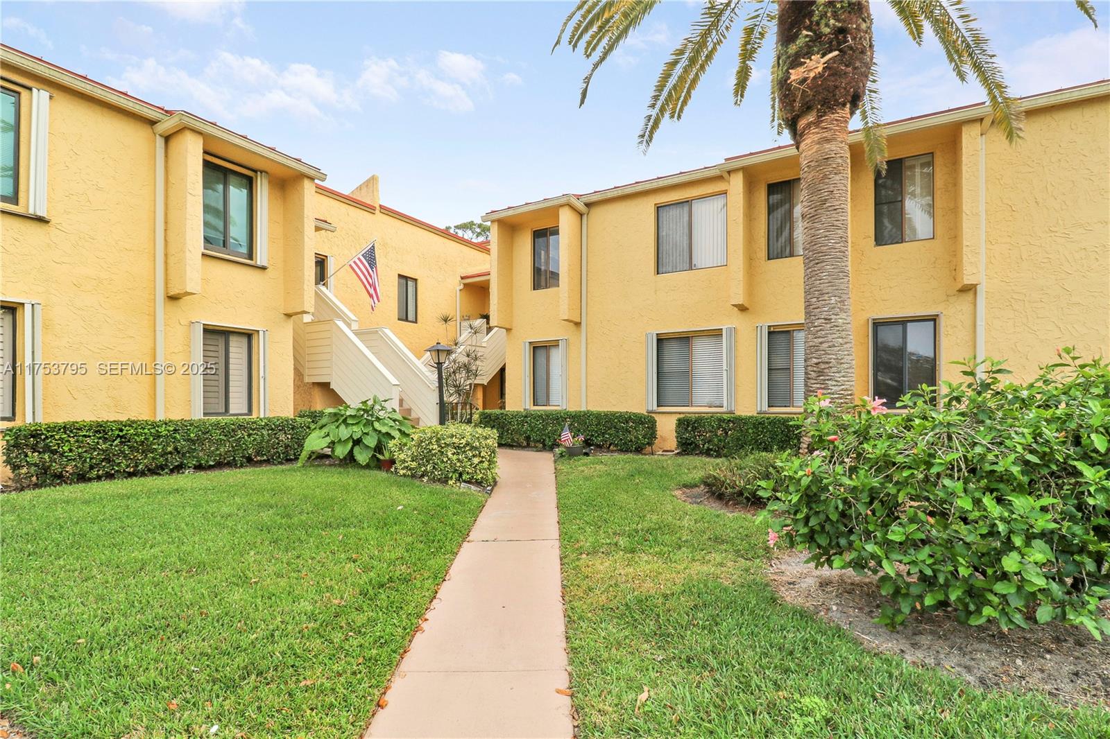 5313 Southeast Miles Grant Road, Unit 206 Stuart, FL 34997 - Photo 28 of 39 a front view of a house with a yard